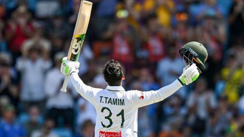 Tanzid Hasan Tamim raising his bat and looking to the sky after reaching his century.