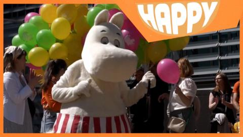 A moomin character and thge Happy logo