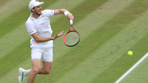 Jamie Murray hits a tennis ball at Wimbledon