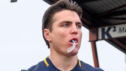 Head and shoulders of Catalans Dragons player Zac Lipowicz with his gumshield hanging from his mouth