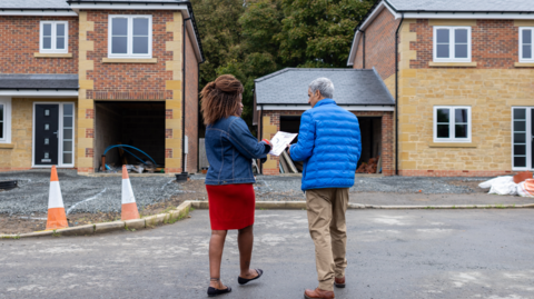 Man and woman outside new build homes 