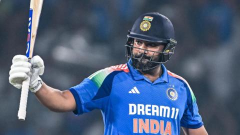 India captain Rohit Sharma raises his bat after reaching a century