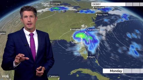 Chris Fawkes standing in front of a weather map of the US