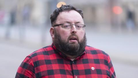 Neil Speakman in red and black checked shirt - he has beard and glasses 