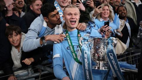 Erling Haaland celebrates winning the EFL Cup trophy with Manchester City supporters