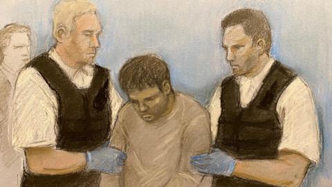 Court artist sketch by Elizabeth Cook of Safi Dawood being led into court by two offices at Westminster Magistrates' Court in London, where he was charged with murder after a triple stabbing in Uxbridge.   He is wearing a greyish-brown top and handcuffs.