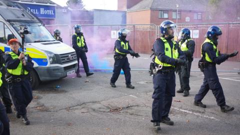 police dealing with flares during unrest in Epping