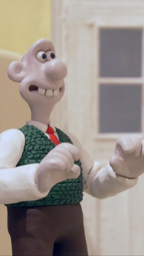 Image of Wallace wearing his iconic brown trousers and green vest.