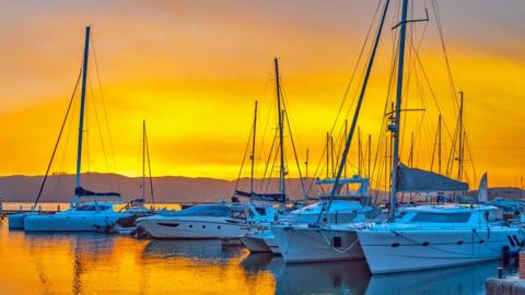 Boats moored in Knysna's waterfront at sunset.