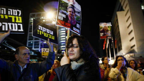 A woman holds a sign with the image of a hostage kidnapped during the 7 October attacks.