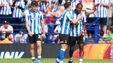 Sheffield Wednesday players, wearing the Owls blue and white striped home shirt, celebrate Jamal Lowe's goal in the EFL Cup against Bolton.