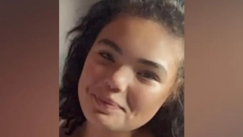 Lily is smiling at the camera in this close-up image. She has long brown hair.