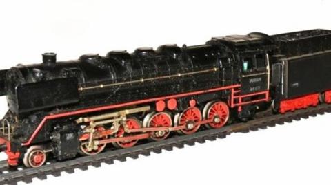 A black model train with red wheels and red paint pictured on tracks before it was stolen