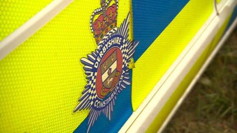 A close-up shot of a Derbyshire Police crest on a police vehicle 