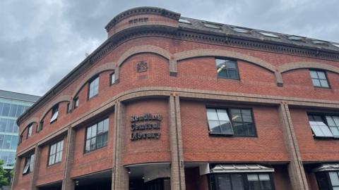 A large brick building with lettering on the front saying 'Reading Central Library'