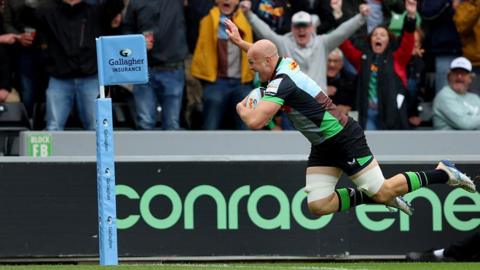 Tom Lawday raises his hand in celebration as he dives over for the winning try