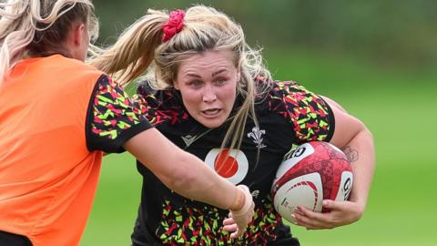 Alex Callender carries the ball in a Wales training session