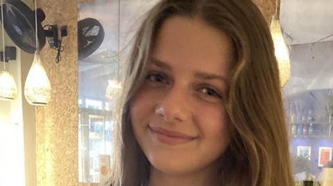 A photo of Eleanor Hague. She has long light brown hair and is smiling