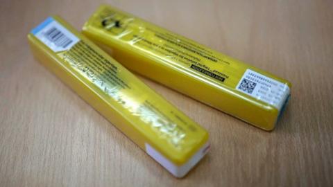 Two yellow packets of naloxone , which look similar to sweet packets.