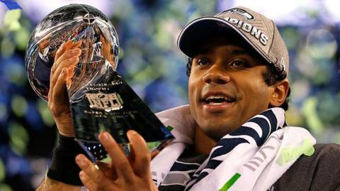 Russell Wilson holding the Lombardi Trophy after the Seattle Seahawks win the Super Bowl in 2014