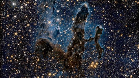 A dark blue sky littered with stars of white and yellow. A black smudge-looking blob sits in the middle.