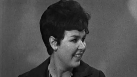 Black and white image of Daphne Cohen in a black jacket, smiling looking towards her left