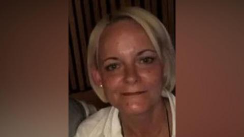Tracey Smith, a middle-aged woman with cropped blonde hair. She is smiling in the photo.