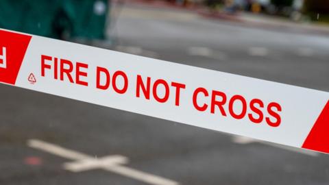 Red and white tape with "Fire, Do Not Cross" written on it.