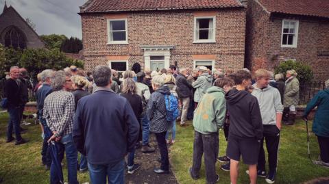 Locals gatherering to see the plaque unveiled