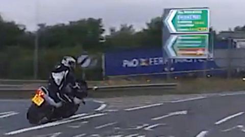 Motorcyclist speeds around roundabout.