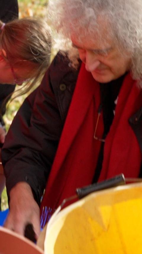 Sir Brian May planting daffodils.
