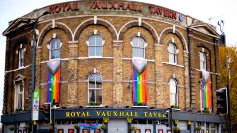 Exterior of the Royal Vauxhall Tavern with LGBTQ+ flags hanging from three windows