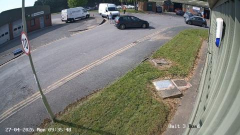 CCTV footage shows a white van driving towards a woman in the road stood next to a car