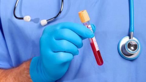 Doctor holding blood in test tube