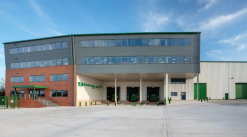 A large warehouse which looks very modern and has a green sign which says 'Gompels' near the entrance.