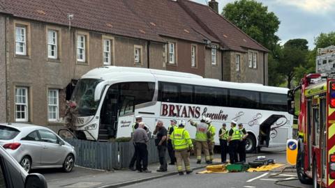 A coach smashed through the front wall of one house