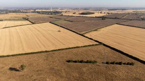 An overhead shot showing a patchwork of brown, dried out fields in Northamptonshire.