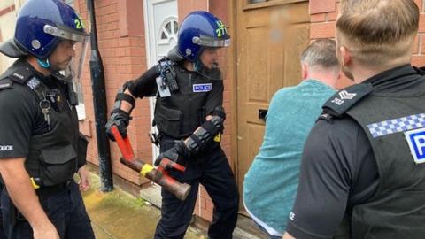 Police officer about to break down a door