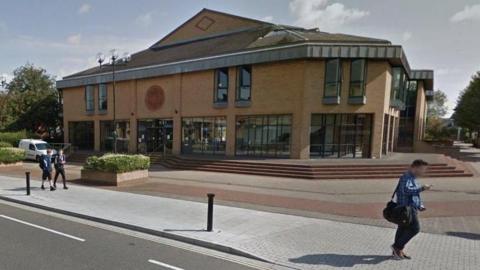 Exterior of Lincoln Magistrates'' Court - a modern two-storey building of light coloured brick with larges glass windows all along the ground floor