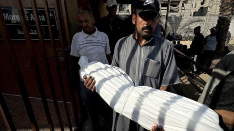 The body of 13-year-old Abdul Hamid al-Ghalban, who died as a result of malnutrition, is carried in a white shroud before his funeral, at Nasser hospital in Khan Younis, southern Gaza (22 July 2025)