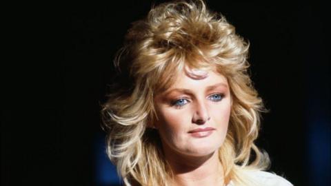 Bonnie Tyler looking at the camera. It is a headshot. 