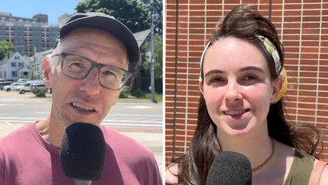 Split screen showing a man wearing a cap and glasses speaking into a microphone, and on the right a woman with a yellow and white headband also speaking into a microphone.