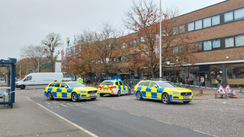 Three police cars parked on Banbury Road, outside the Marks and Spencer food shop. 