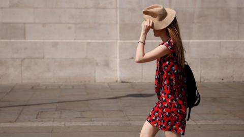 A woman shielding herself from the sun