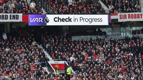 A sign reads 'VAR check in progress' at Old Trafford