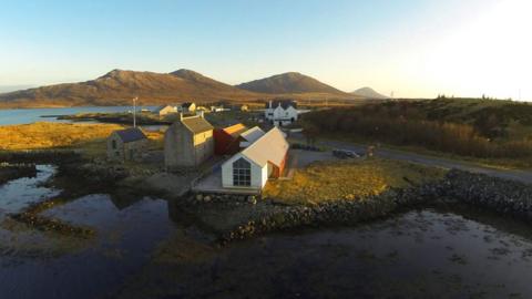 Sealladh do Thaigh Chearsabhagh bho gu h-àrd. Tha a' ghrian a' dol fodha agus tha faileas air pàirt dhen togalach. Tha oidhche bhreàgha ann. 