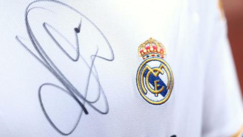 A close up image of a Real Madrid shirt signed by Kylian Mbappe