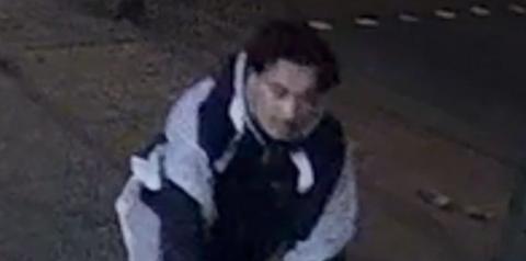 Man wearing grey and blue hoodie near pavement during the night.
