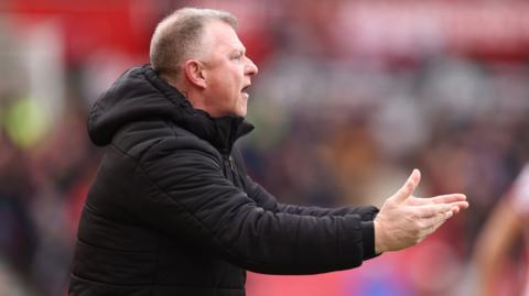 Mark Robins holds his hands out in disbelief