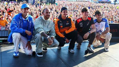 The British drivers - George Russell, Lewis Hamilton, Lando Norris, Oliver Bearman and Arvid Lindblad - pose for a photograph on stage in front of thousands of fans at the British Grand Prix at Silverstone